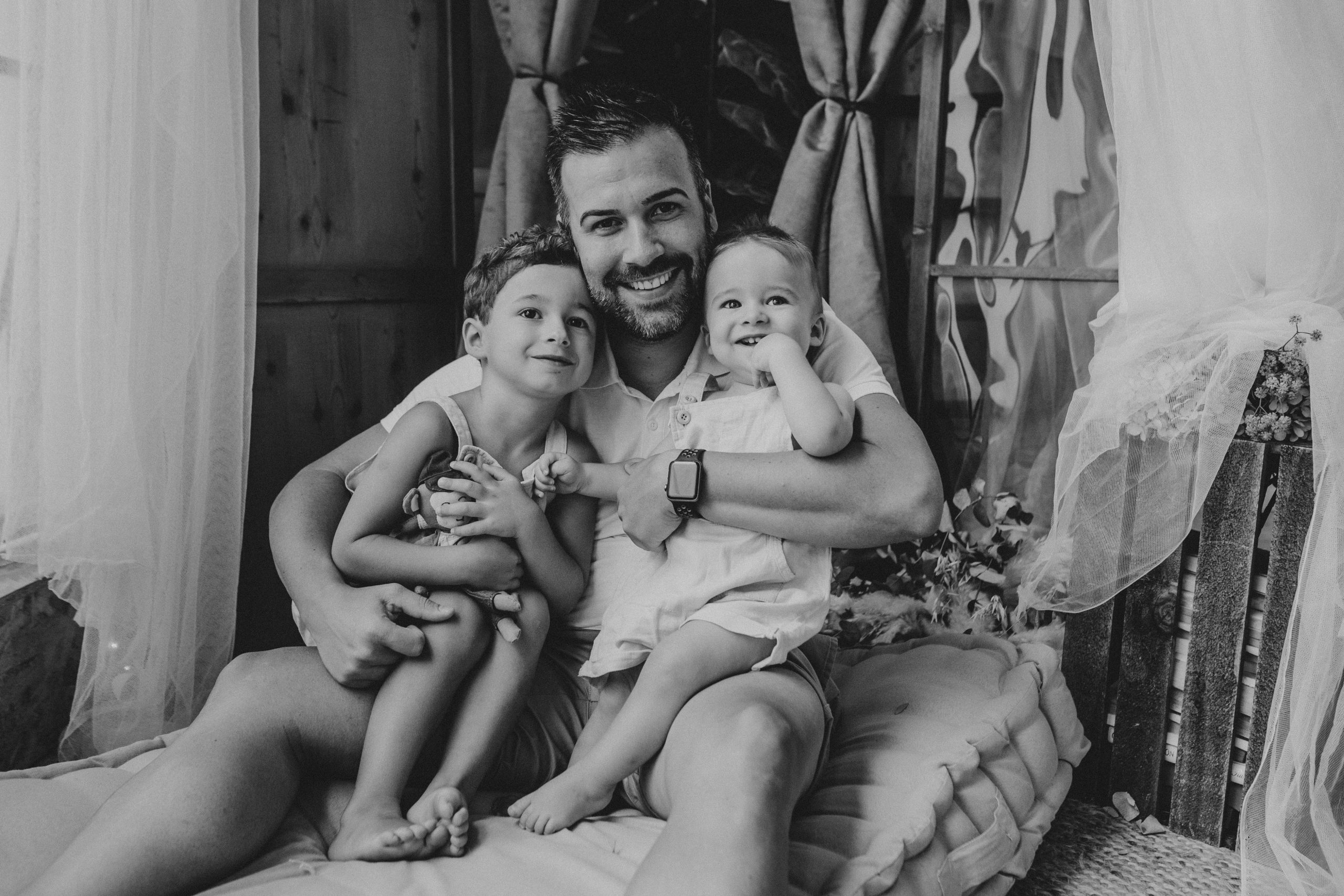 Fotografía en blanco y negro de padre e hijos abrazándose