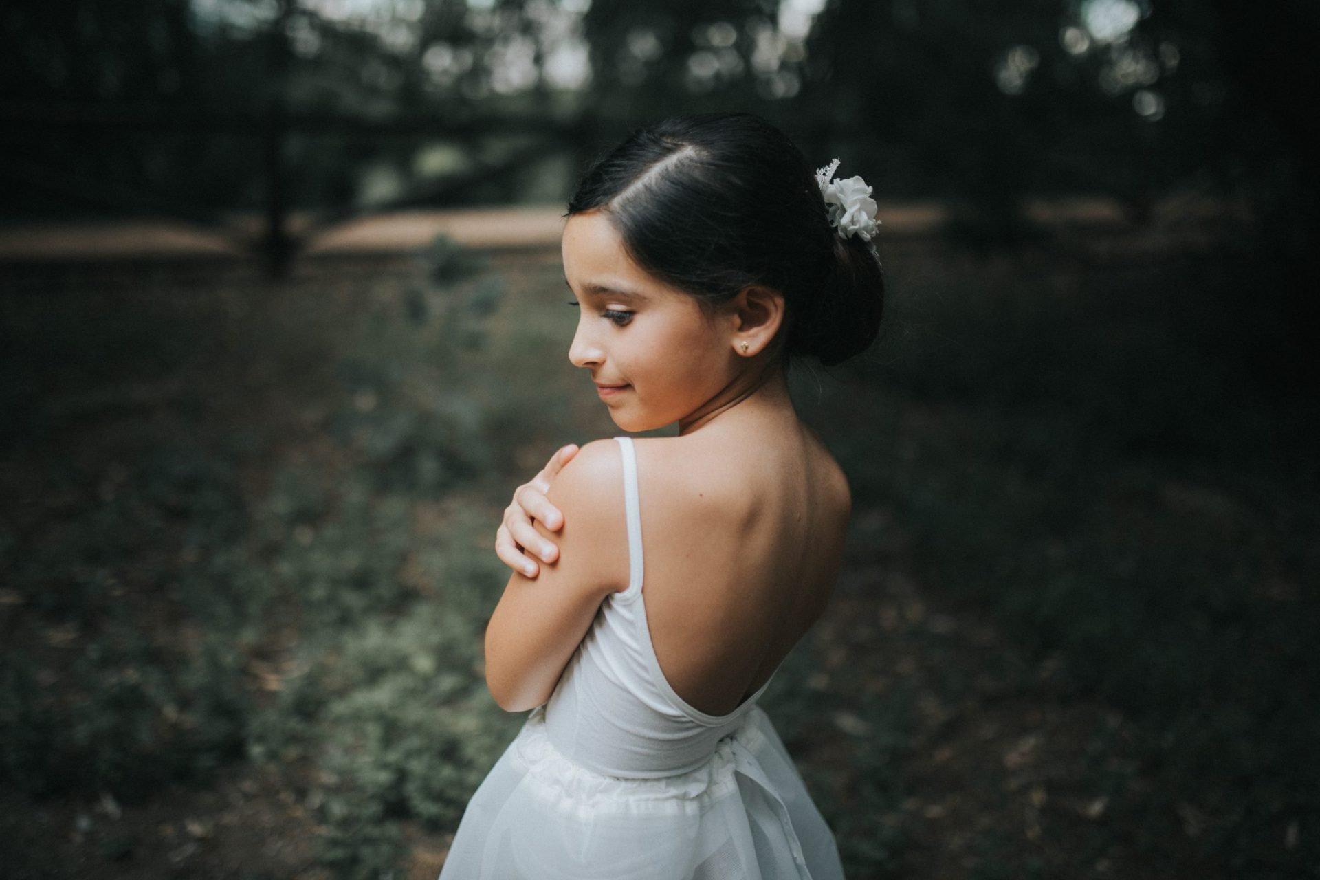 Niña con vestido de comunión en medio del bosque