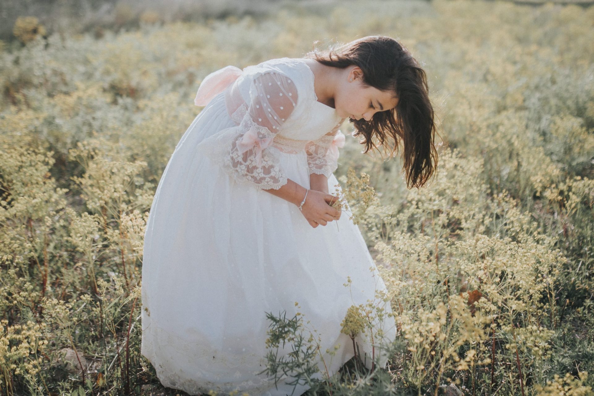 niña con vestido de comunión en el campo
