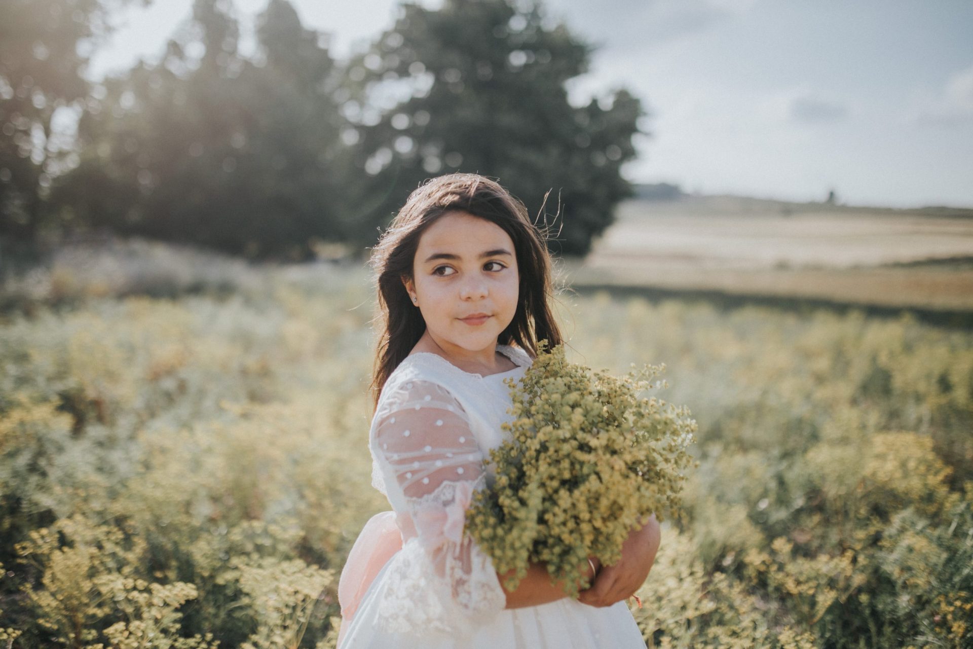 niña con vestido de comunión en el campo