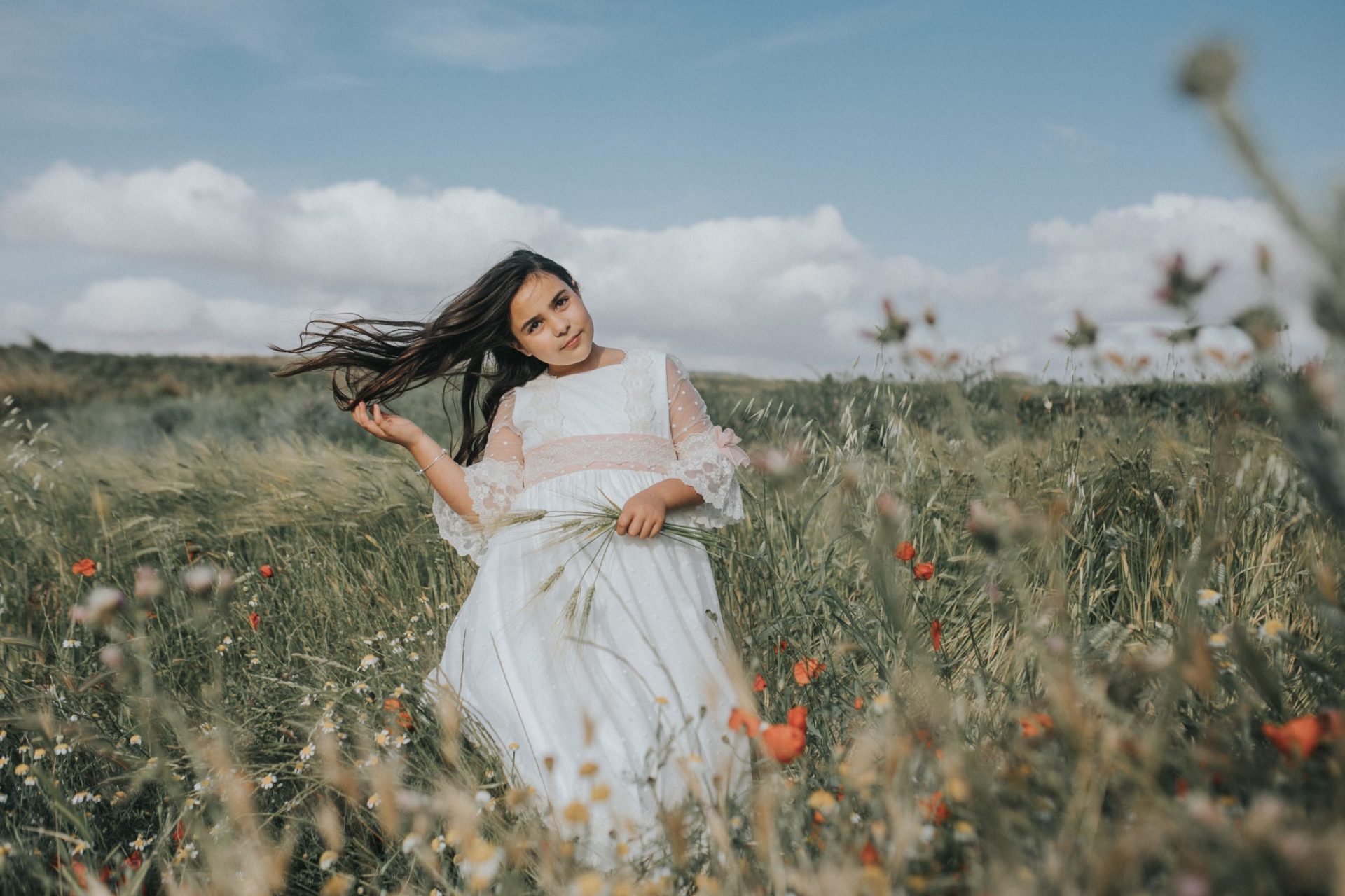 Niña en el campo con vestido de comunión