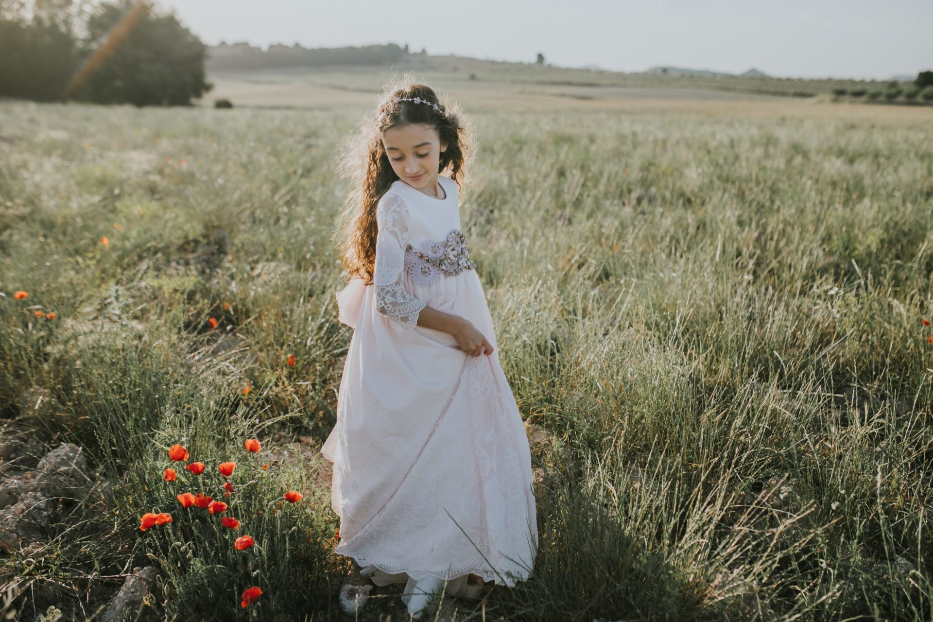 Niña con vestido de comunión en medio del campo