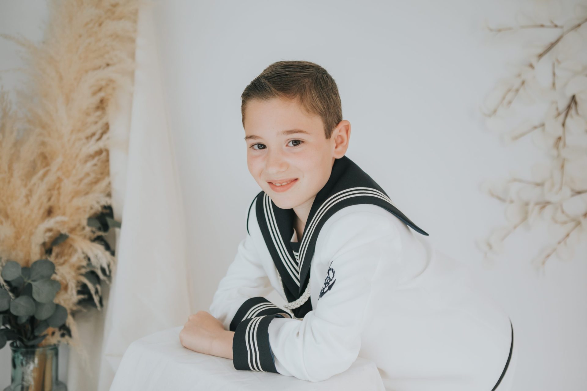 Niño con su traje de comunión con un fondo blanco