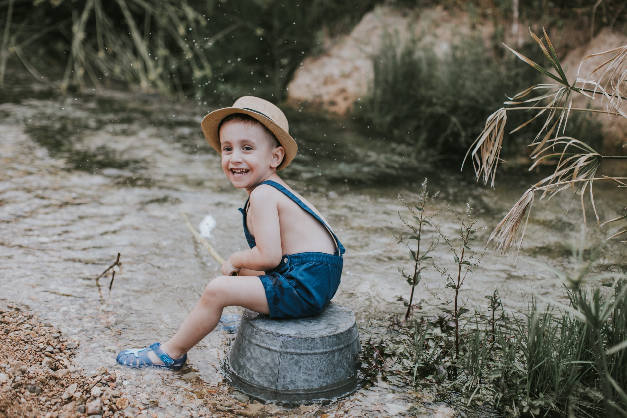 Niño jugando a la orilla de un río