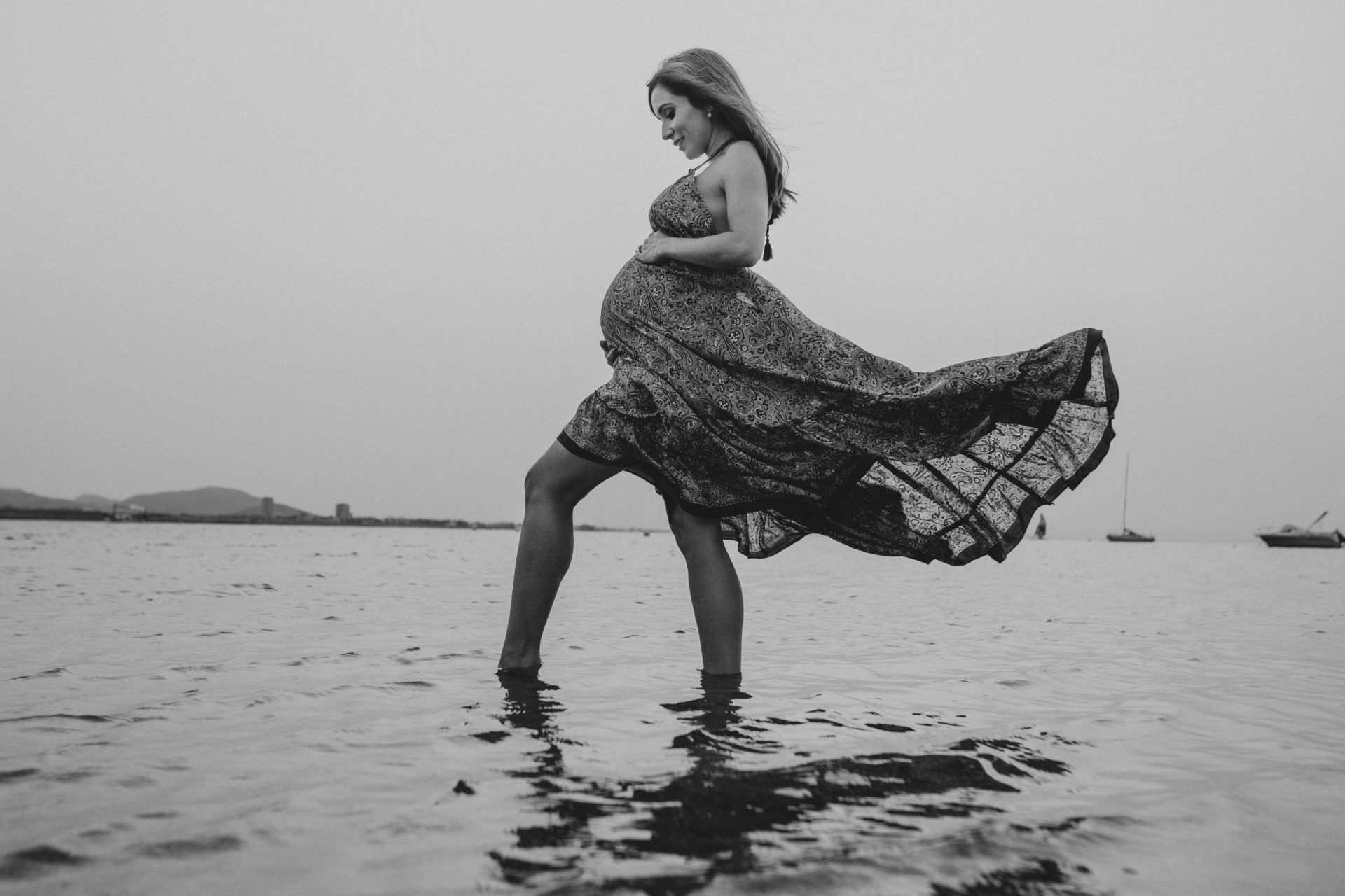 Mujer embarazada en la orilla del mar