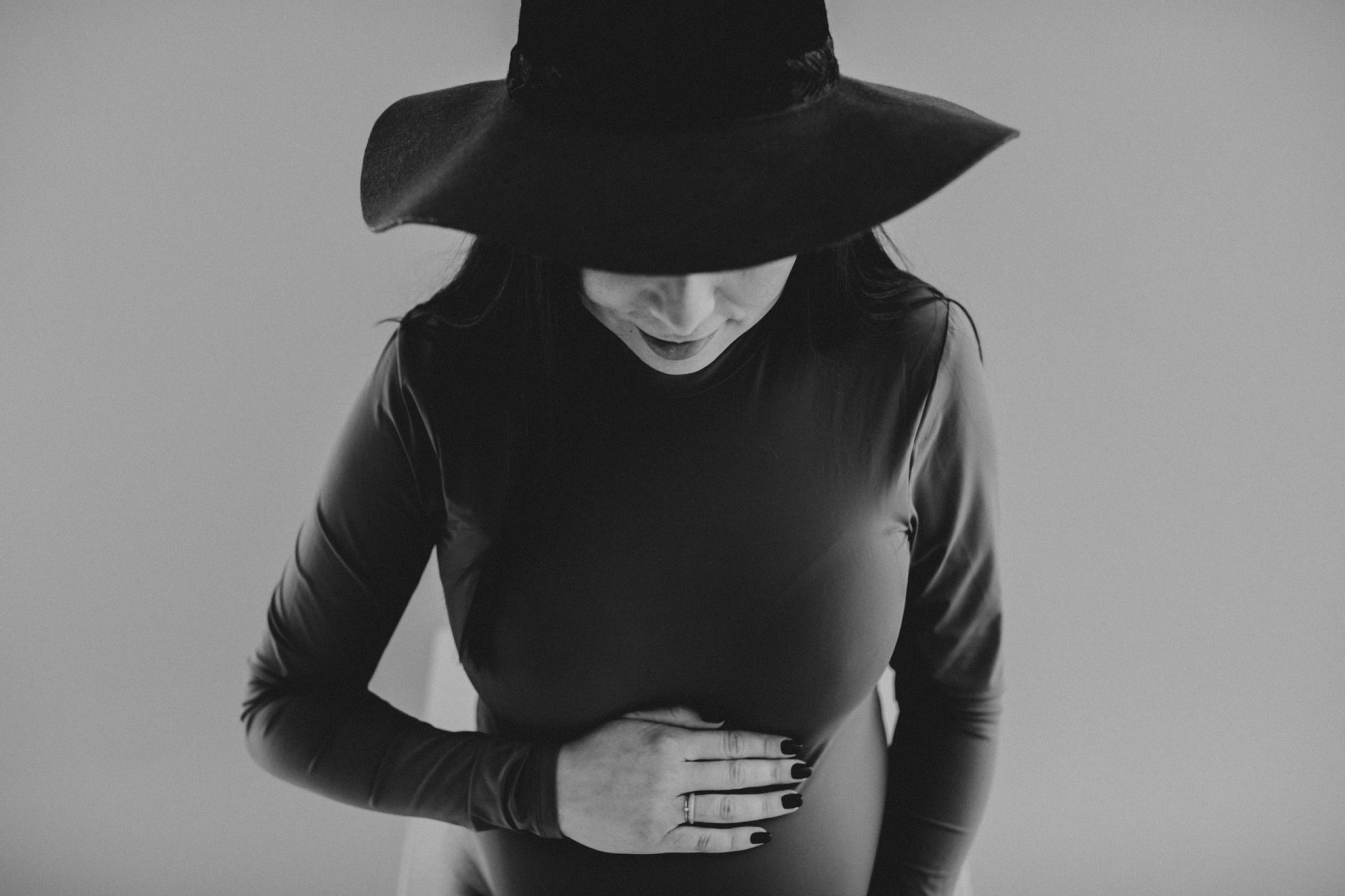 Fotografía en blanco y negro de una embarazada agarrando su barriga