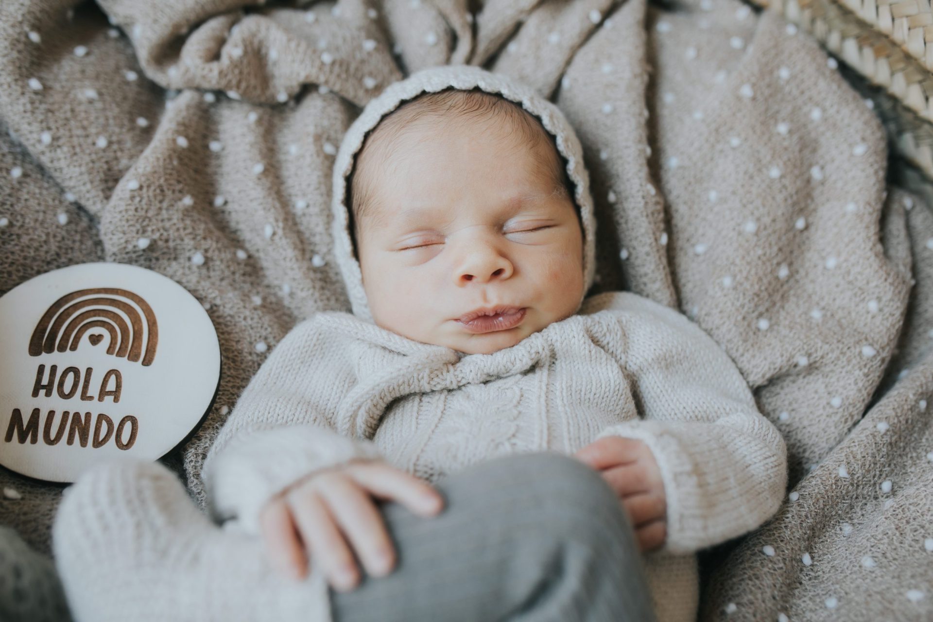 Bebé dormido con ropa y manta beige