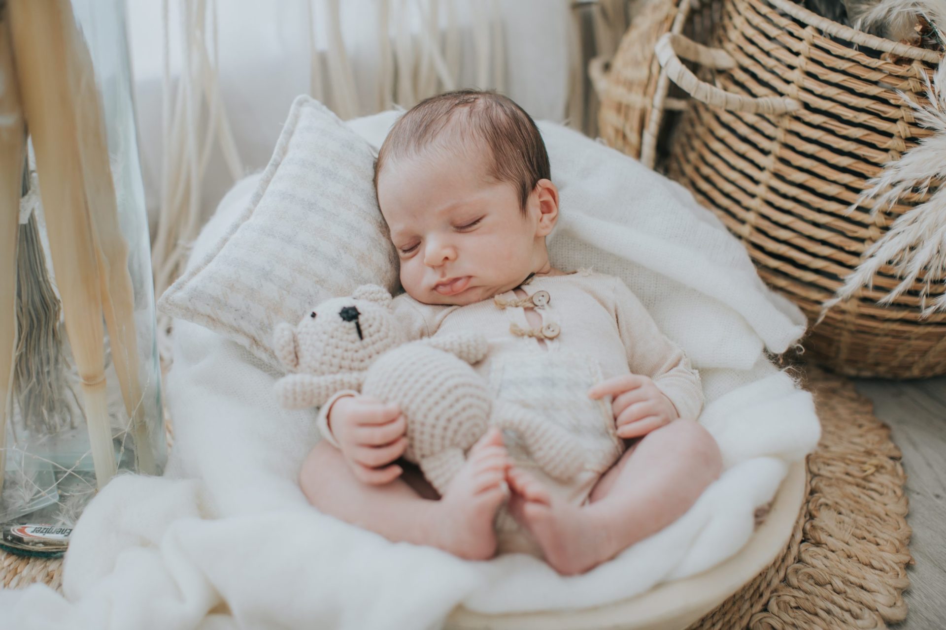 Bebé dormido en una cesta con manta blanca