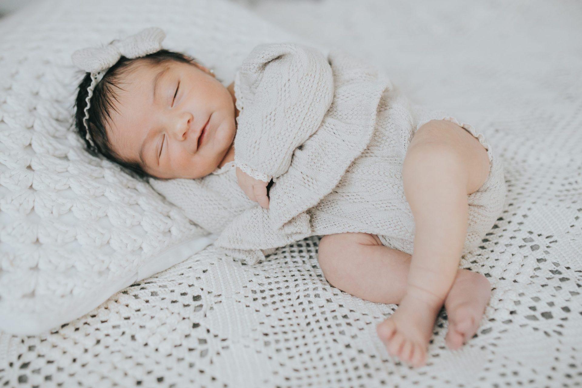Bebé sonriente acostado sobre una manta beige