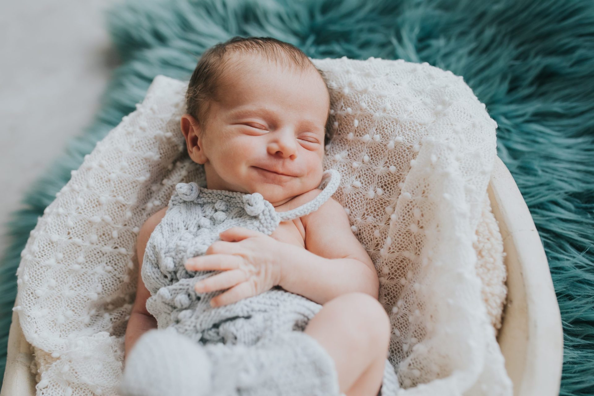 Bebé sonriente acostado en una cesta