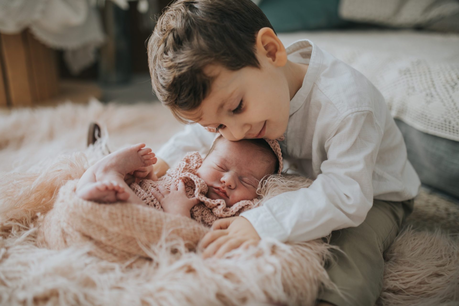 niño abrazando a su hermano recién nacido